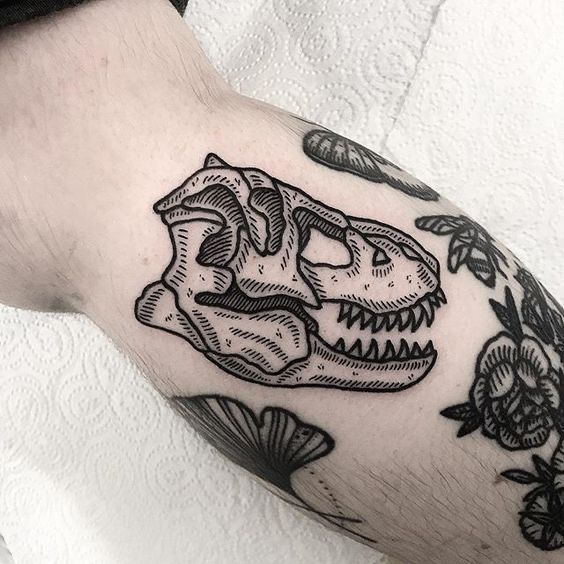 a close up of a person's arm with a dinosaur tattoo on it,