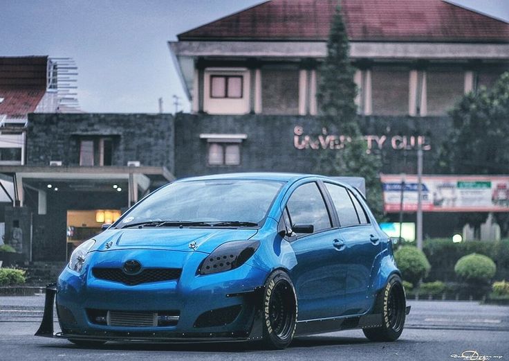 a blue car parked in front of a building