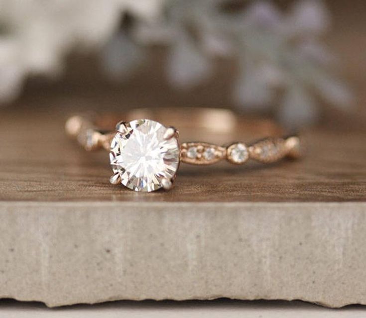 a close up of a diamond ring on a wooden surface