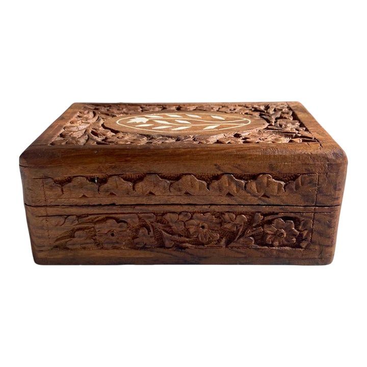 an intricately carved wooden box on a white background