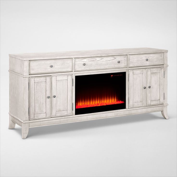 a white entertainment center with an electric fire in the fireplace on it's side