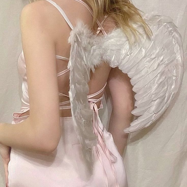 a woman in a pink dress with angel wings on her back