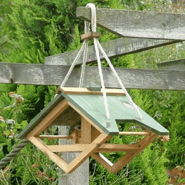 a bird feeder hanging from a wooden post