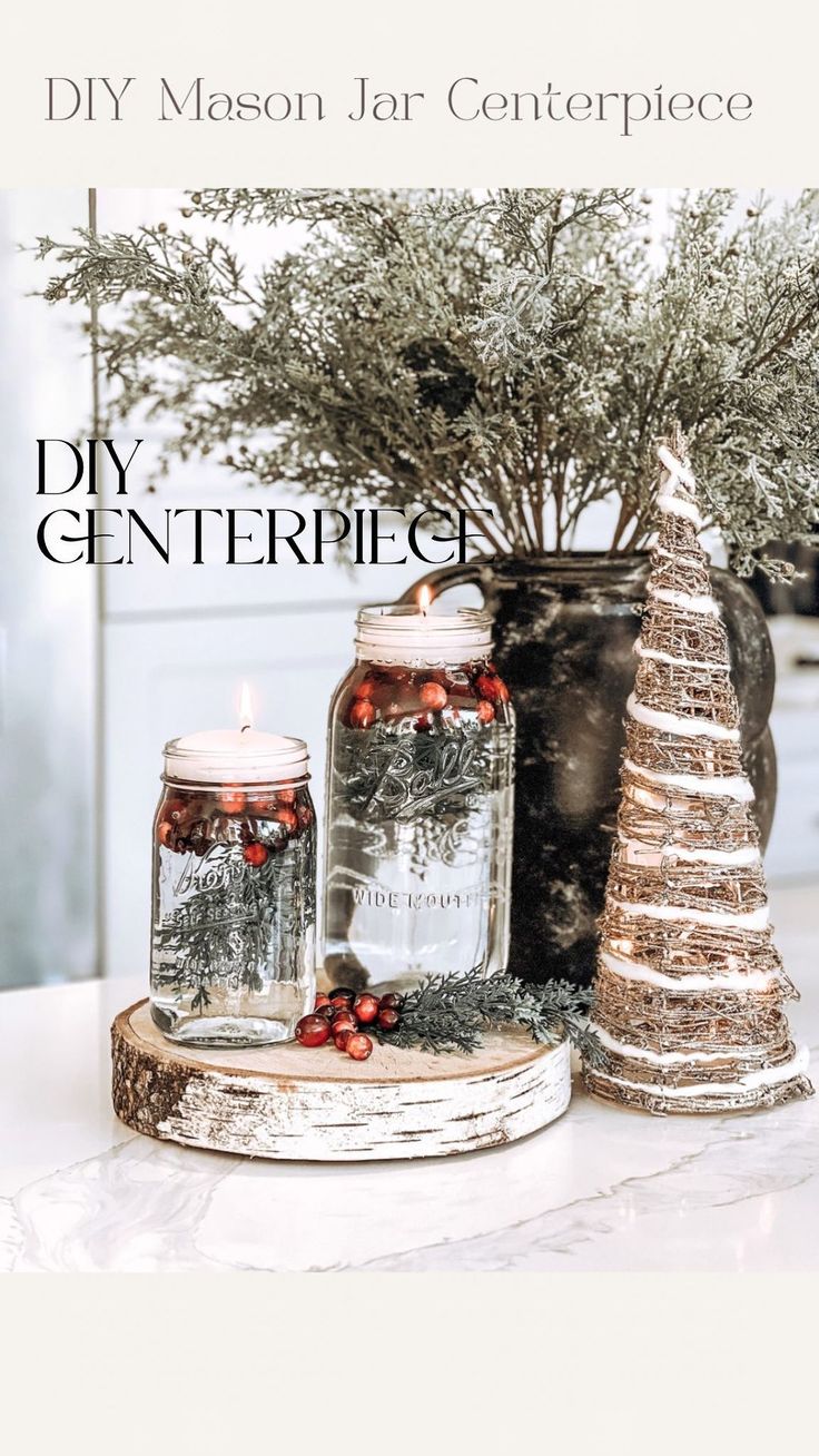 two jars with candles are sitting on a table next to a christmas tree and potted plant