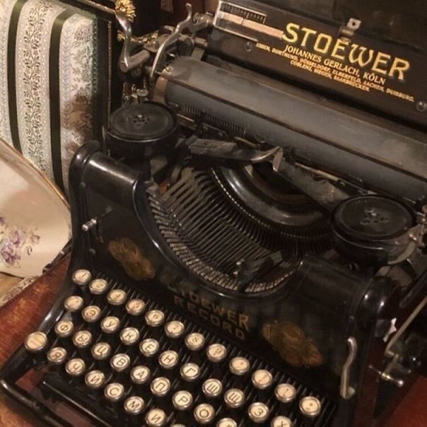 an old fashioned typewriter sitting on top of a wooden table