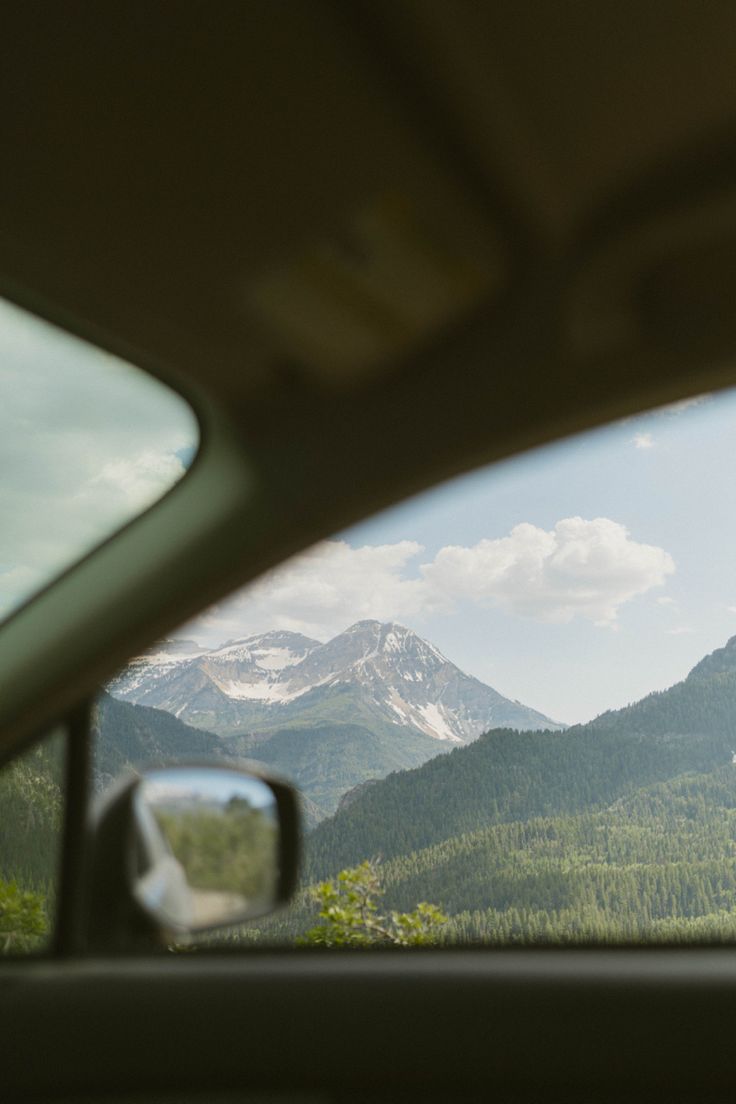 the view from inside a car looking at mountains