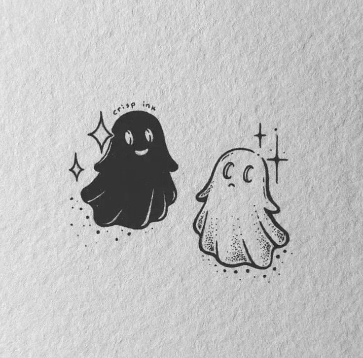 two black and white ghost stickers are on top of paper, one is drawn with ink