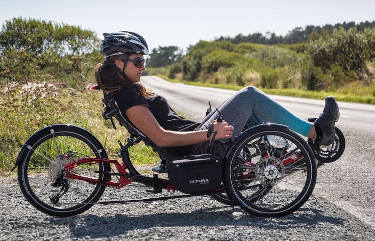 a woman sitting in a motorized bike on the road