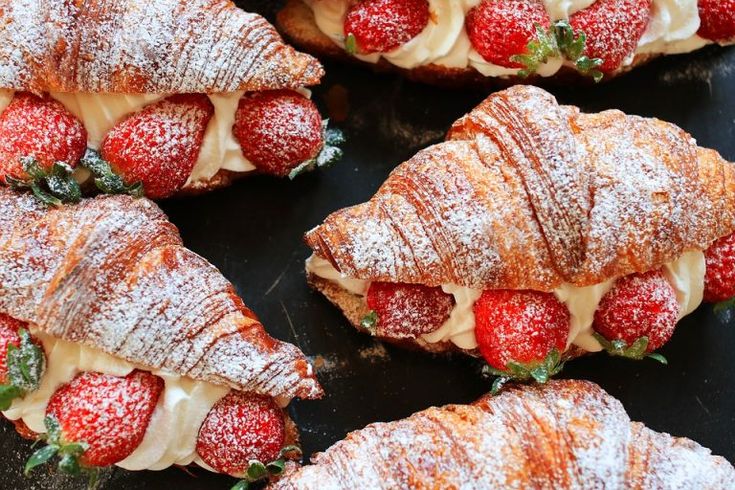 strawberry croissants covered in powdered sugar and topped with strawberries