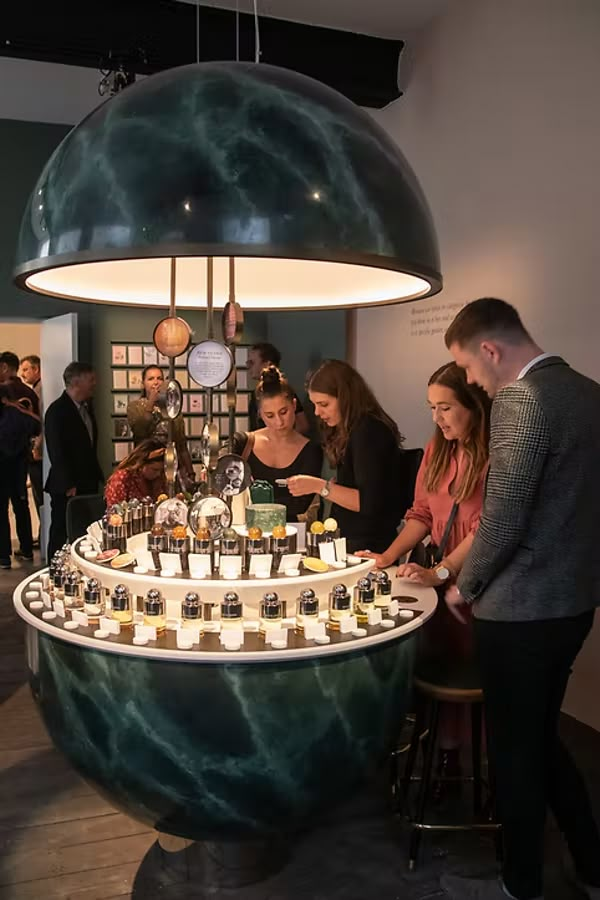 people standing around a table with bottles on it