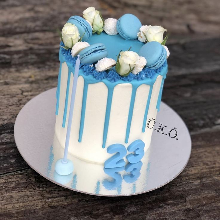 a blue and white decorated cake sitting on top of a wooden table