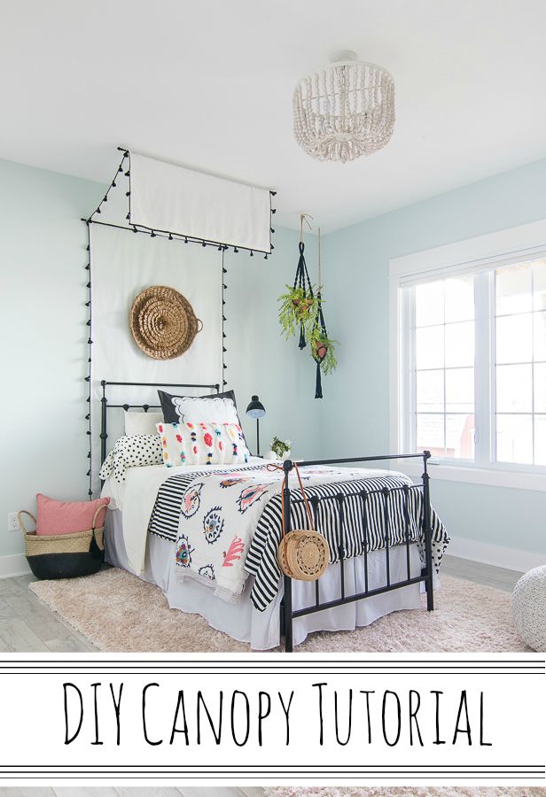 a bed room with a neatly made bed and a chandelier hanging from the ceiling