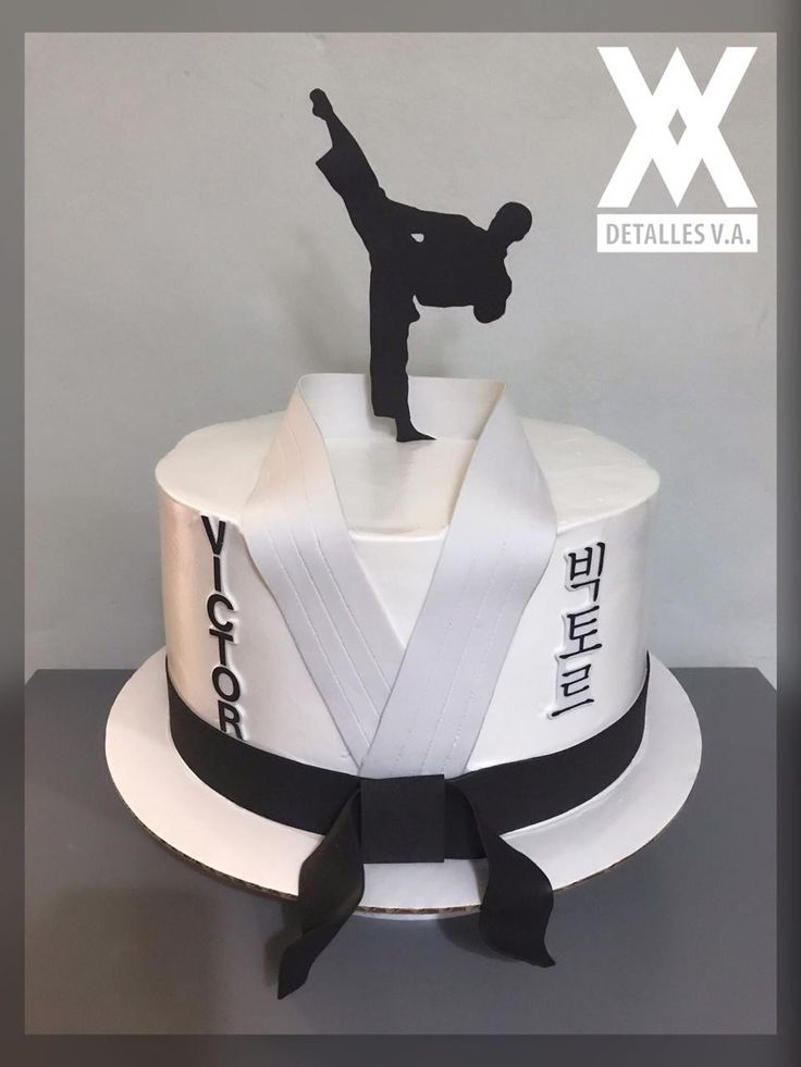 a white cake with black ribbon around it and a karate figure on top that says, yoyotchoku