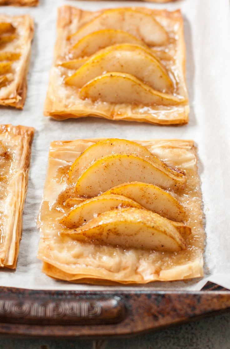 apple tarts sitting on top of a baking sheet