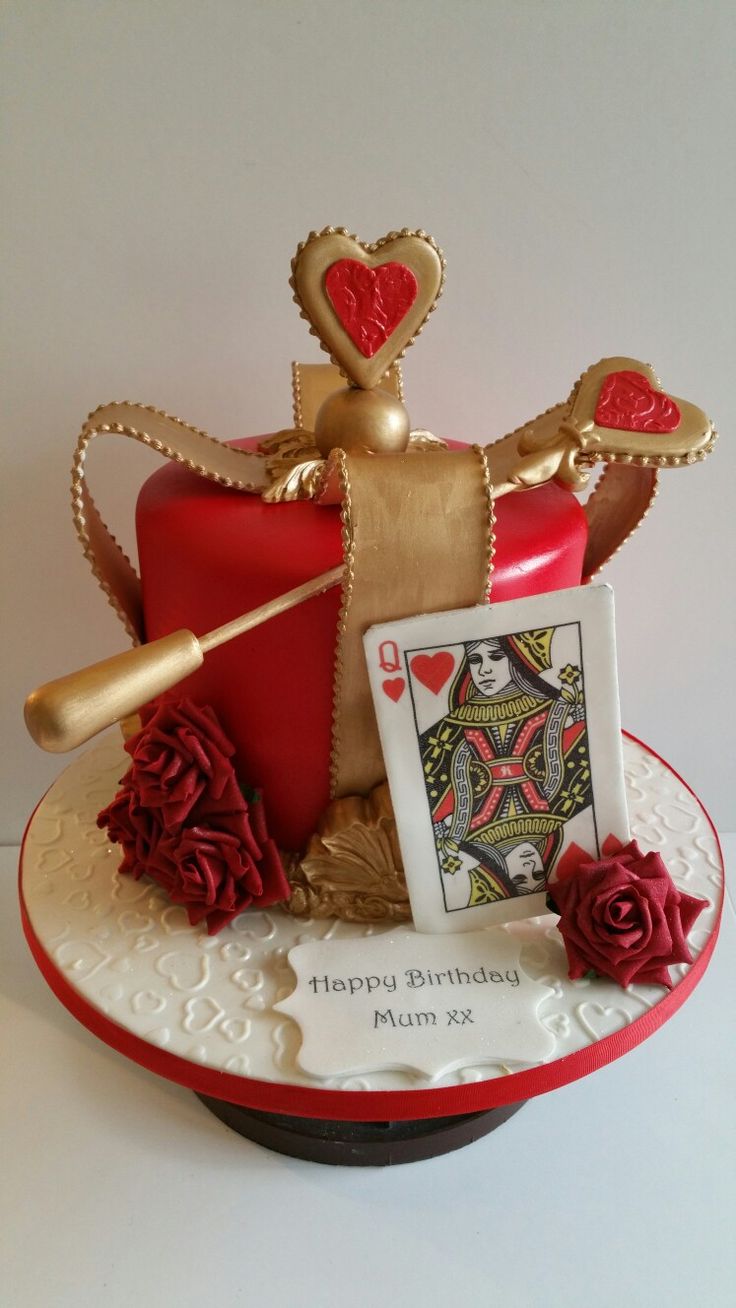 a red and white cake with a card on it's plate next to a rose