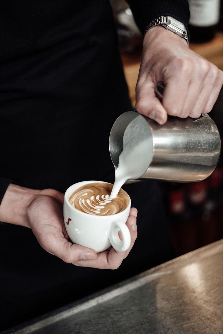 a person pours coffee into a cup