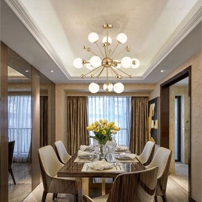 the dining room table is set for four with white chairs and yellow flowers in vases