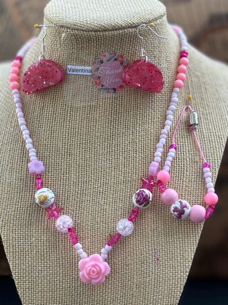 This beautiful pink beaded necklace set is perfect for adding a touch of girly glam to any outfit. The set includes a long necklace with a variety of pink beads, including pink glass beads, pink acrylic beads, and pink seed beads. A sparkling pink star charm and a delicate rose charm add a touch of whimsy to the design. The necklace is finished with a lobster clasp closure. The set also includes a shorter necklace with pink beads and a magnetic clasp closure. Adjustable Pink Beaded Necklace With Faceted Beads, Adjustable Pink Faceted Beaded Necklace, Pink Heart Beads Jewelry For Party, Pink Beaded Chain Jewelry For Gift, Pink Faceted Beads Necklaces For Gifts, Adjustable Pink Jewelry With Faceted Beads, Pink Faceted Beads Jewelry For Gift, Adjustable Pink Beaded Jewelry, Pink Faceted Beads Necklace For Gift