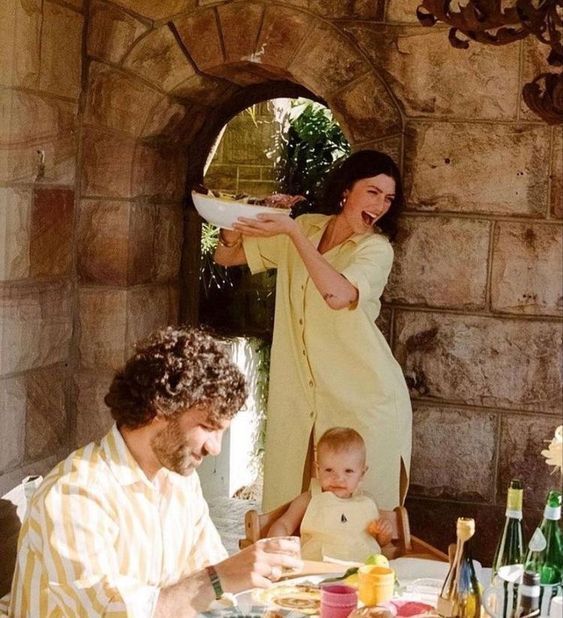 a man and woman sitting at a table with a baby