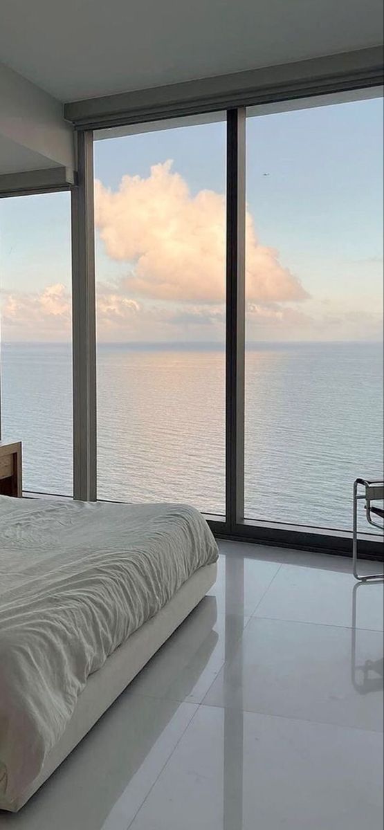 a bedroom with a large window overlooking the ocean