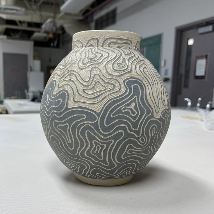 a white and black vase sitting on top of a table