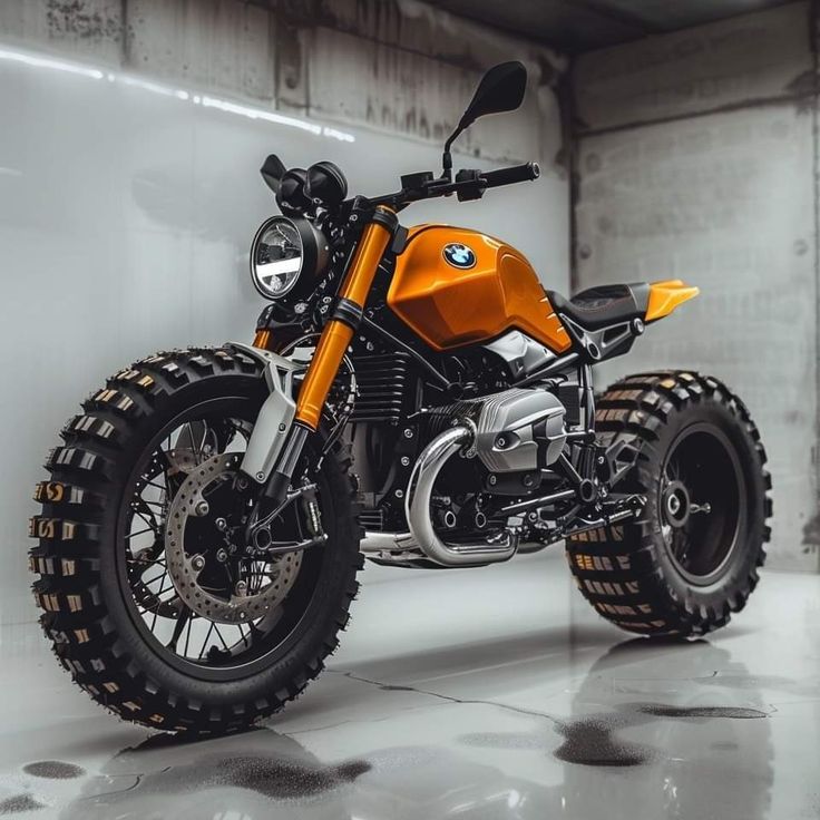 an orange motorcycle parked in a garage next to a white wall and black rims