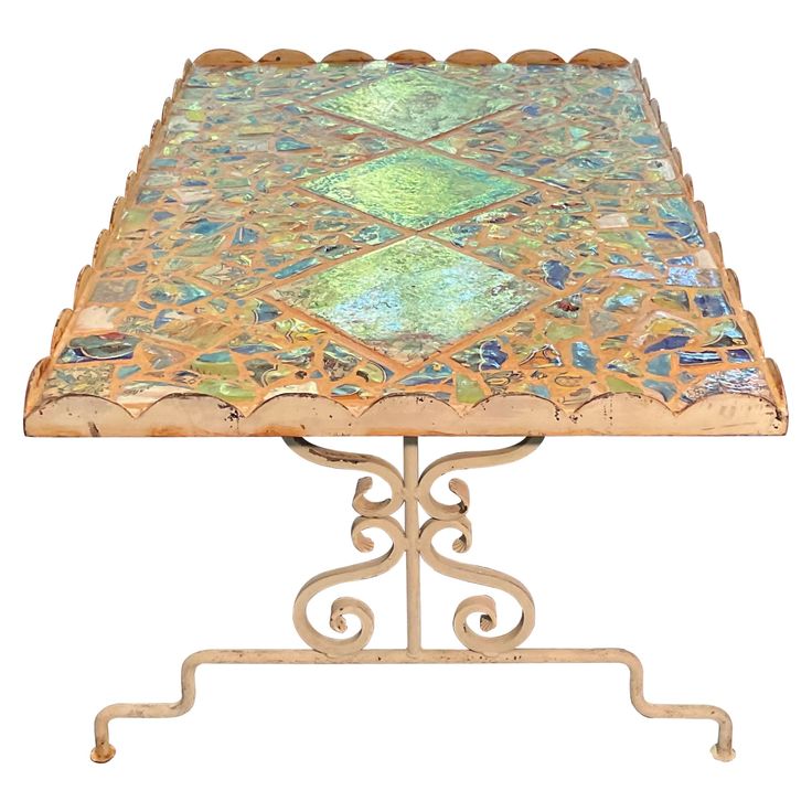 an ornately designed metal table with green and blue tiles on it's top