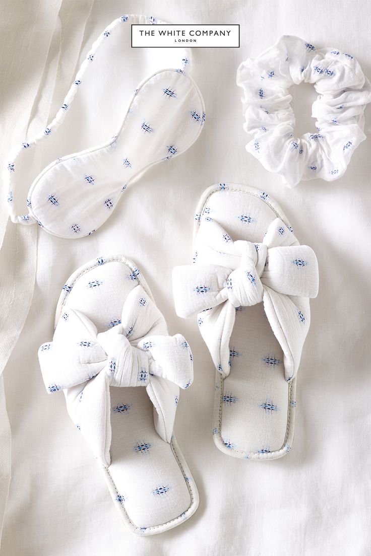 the white company shoes and headbands are laid out on a bed with sheets