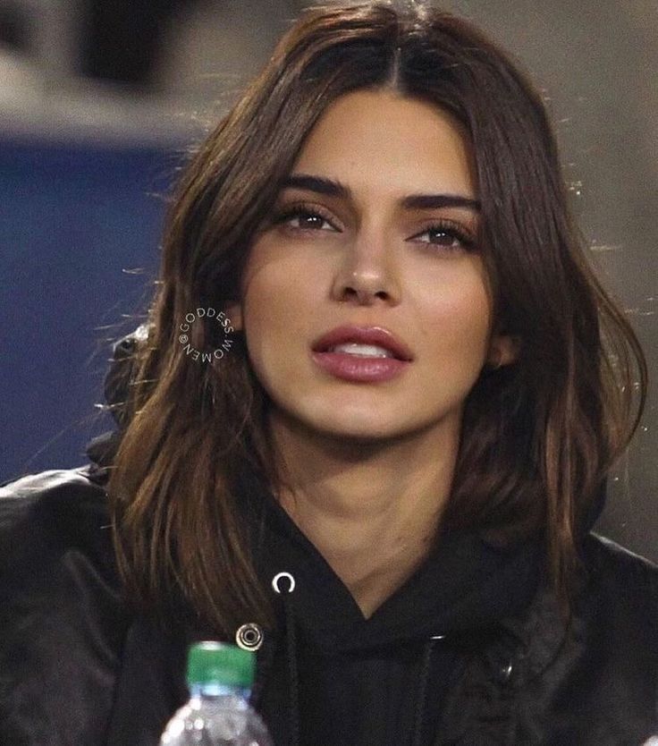 a close up of a person sitting at a table with water bottles in front of her