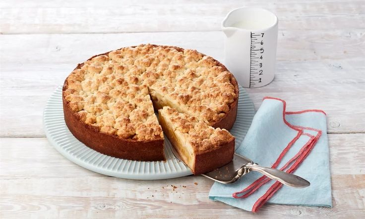 a cake sitting on top of a white plate next to a knife and fork in front of it