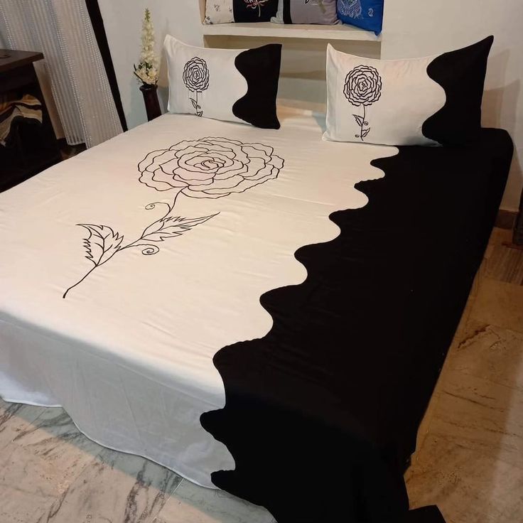 a black and white bed with roses on it