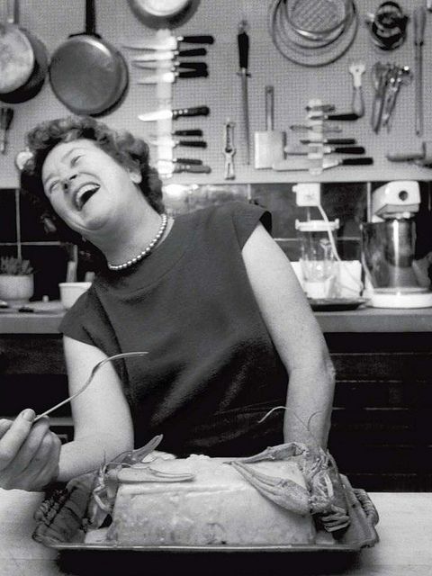 a woman sitting at a table with a cake in front of her and an open mouth