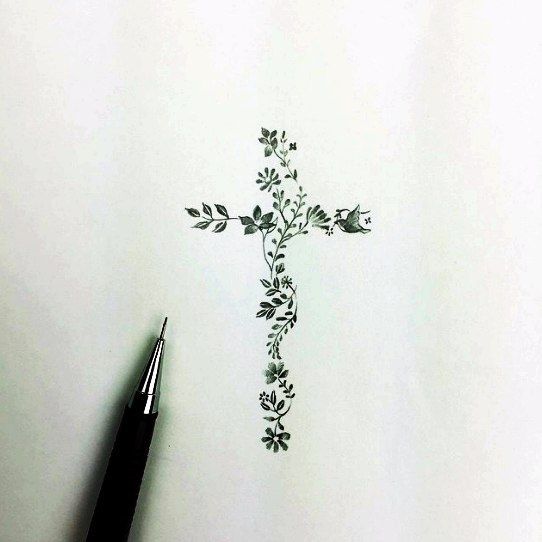 a drawing of a cross with flowers on it and a pen in the foreground