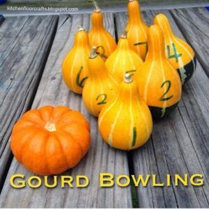 several gourd bowling pumpkins sitting on top of a wooden table next to each other