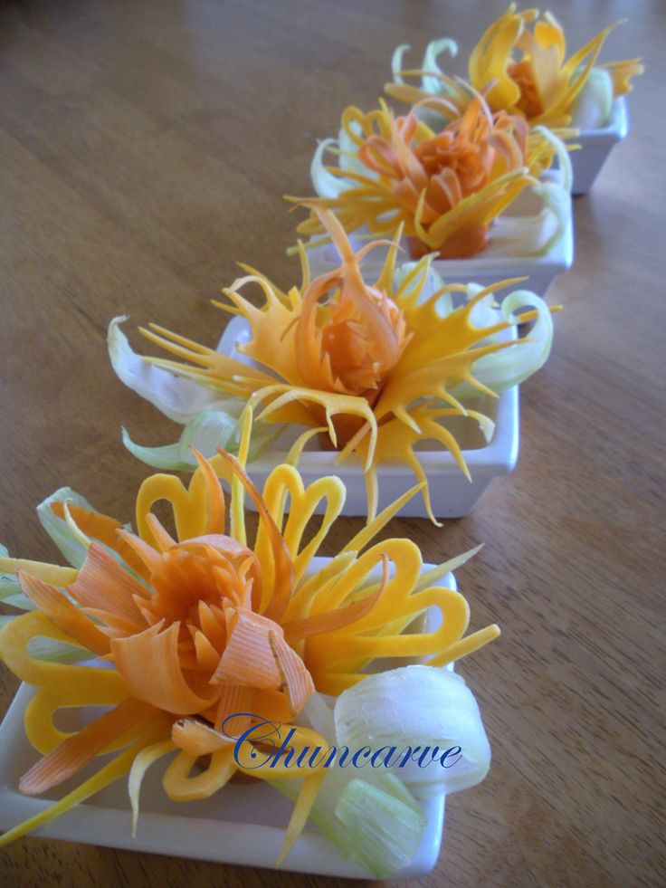 small white trays with yellow and orange flowers in them