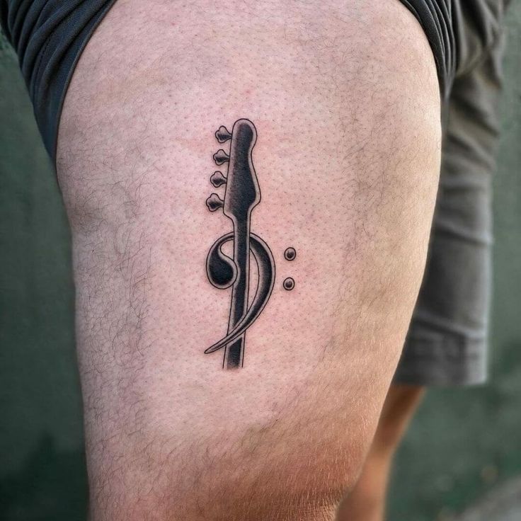 a man's leg with a musical note tattoo on the side of his thigh