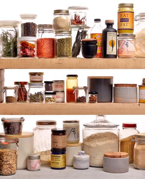 an assortment of spices and condiments on wooden shelves