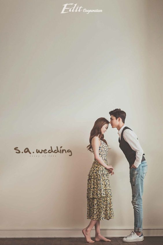 a man and woman standing next to each other in front of a wall with the words s a wedding written on it