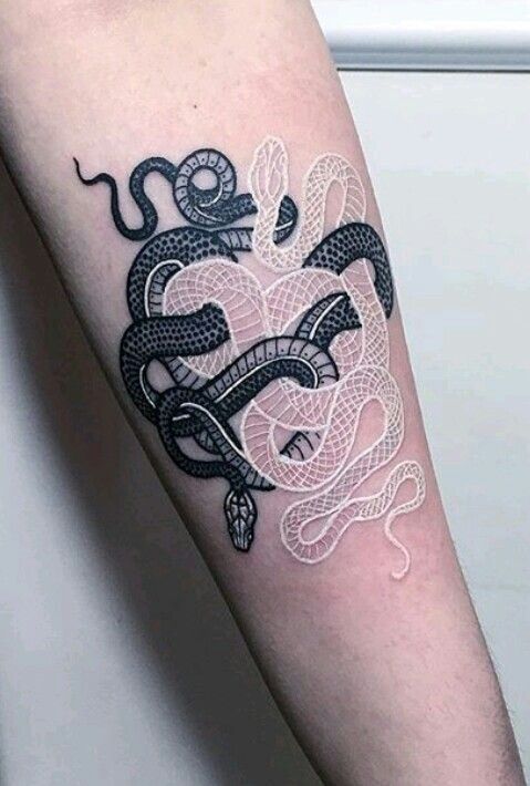 a black and white snake tattoo on the right arm with an intricate pattern around it