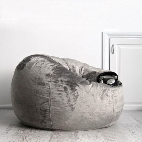 a bean bag chair sitting on top of a hard wood floor next to a white door