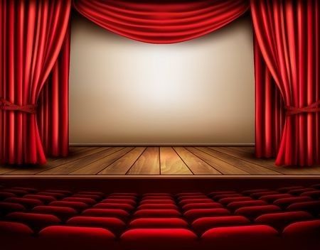 an empty stage with red curtains and seats