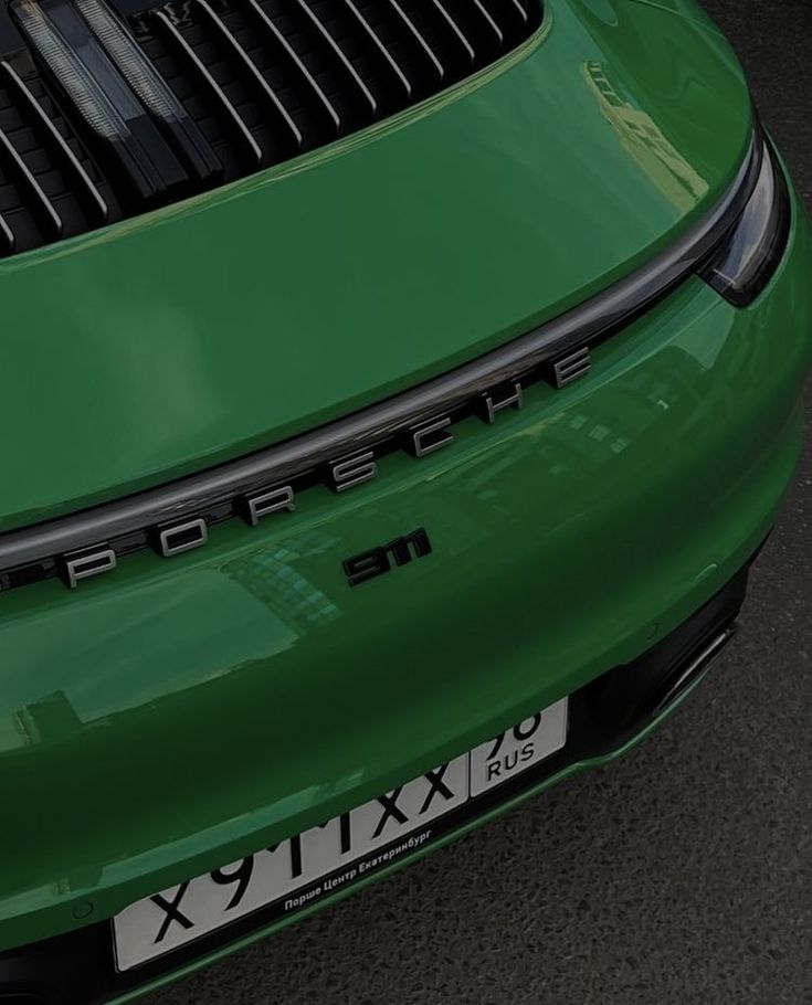 the rear end of a green porsche car