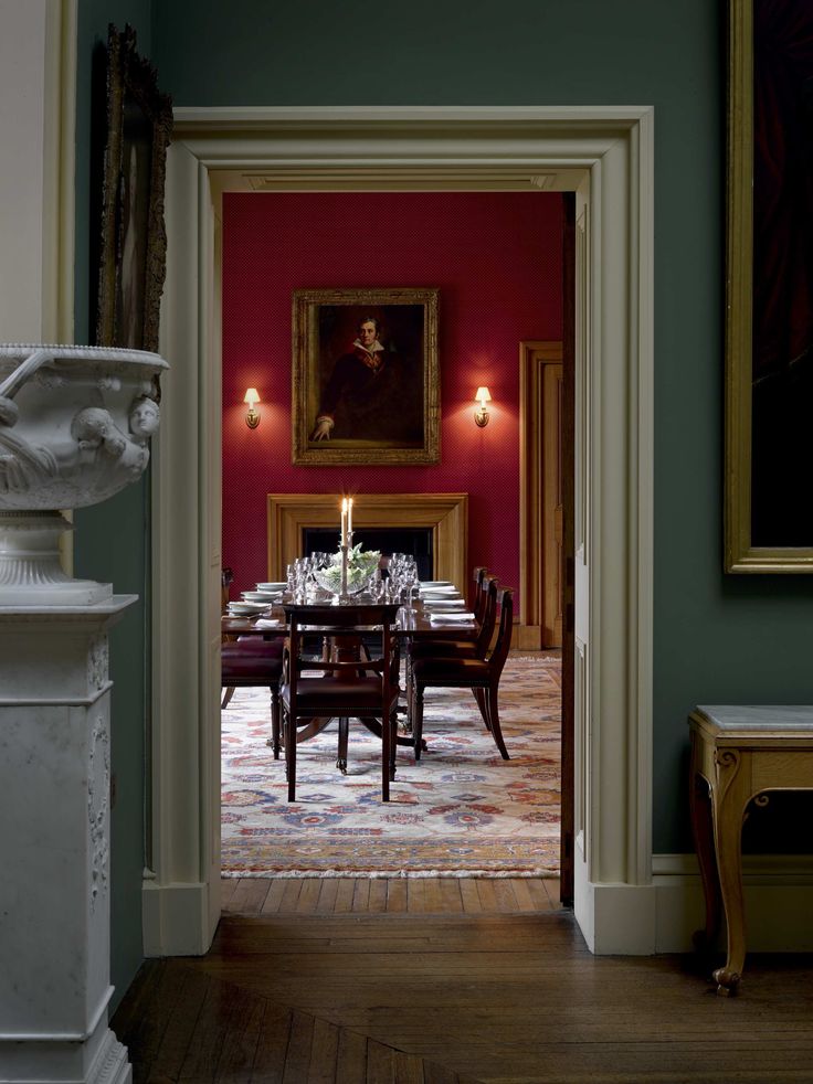 the dining room is decorated in red and green with an ornate table set for four