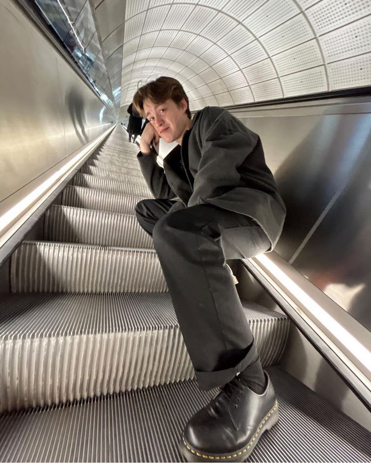 a man sitting on an escalator talking on his cell phone