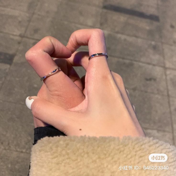 two hands holding onto each other with rings on their fingers