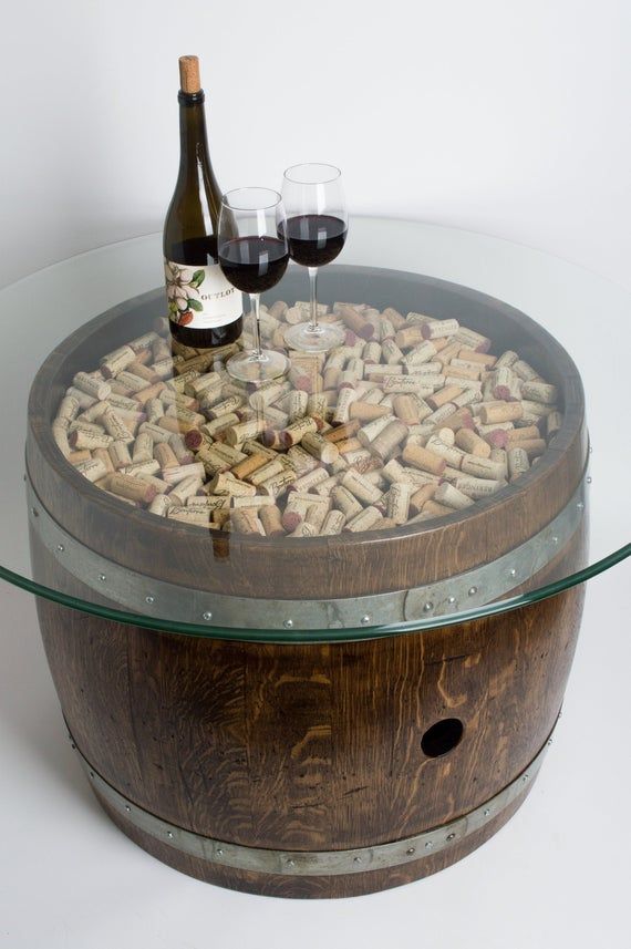 a wine glass and bottle sitting on top of a barrel with corks in it