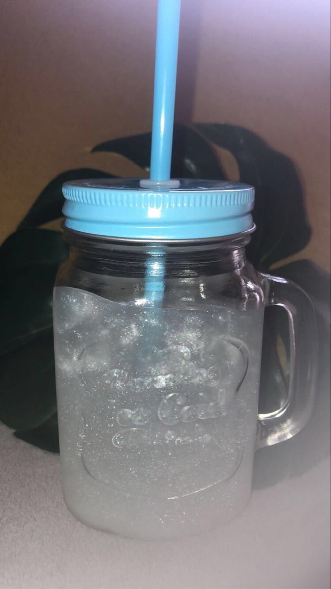 a mason jar filled with liquid and a blue straw