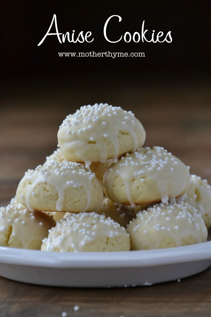 a white plate topped with cookies covered in frosting on top of a wooden table