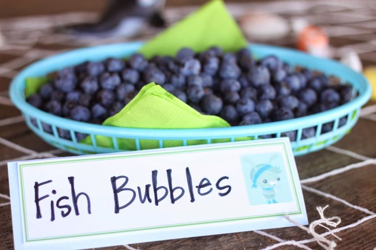 a bowl of blueberries with a sign that says fish bubbles in front of it