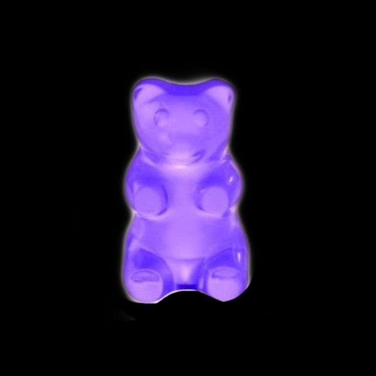 a purple teddy bear sitting in the dark